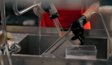 close-up of woman washing dirty dishes in the kitchen after usin